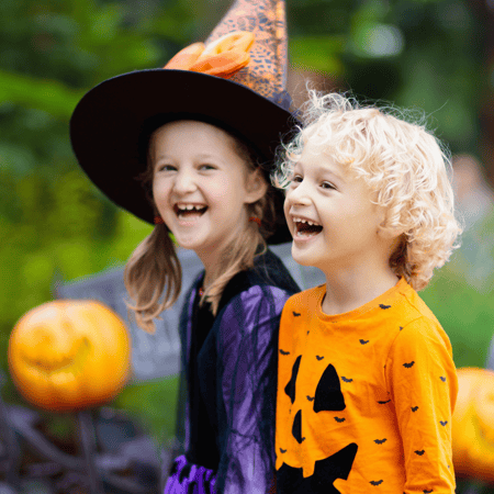 Festive Halloween night scene with children trick-or-treating safely, emphasizing a fun and safe experience