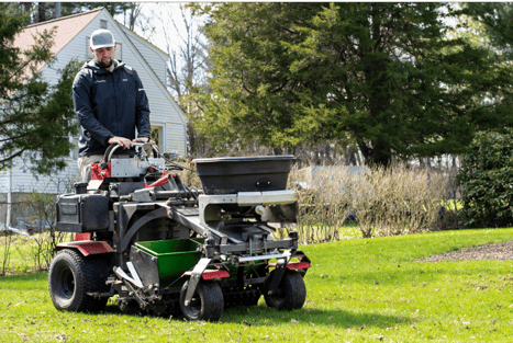 Core aeration machine creating soil plugs to improve lawn health before overseeding